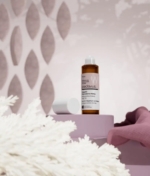 Καλλιτεχνική φωτογραφία peclavus λάδι νυχιών Macadamia με ροζ φόντο.