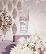 Καλλιτεχνική φωτογραφία peclavus κρέμα χεριών Macadamia με λουλούδια.