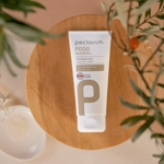 Φυσική κρέμα ποδιών peclavus PODOdiabetic με ουρία τοποθετημένη σε ξύλο με φόντο φυσικά φύλλα