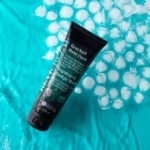 Το Coolfoot ReviCream 100ml τοποθετημένο σε ξύλινη επιφάνεια δίπλα σε λινό ύφασμα και διακοσμητική πέτρα.