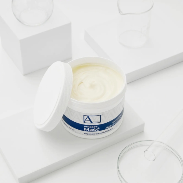 Ανοιχτό δοχείο Arkada’s Ointment με ανοιχτόχρωμη αλοιφή και λευκό βιδωτό πώμα.